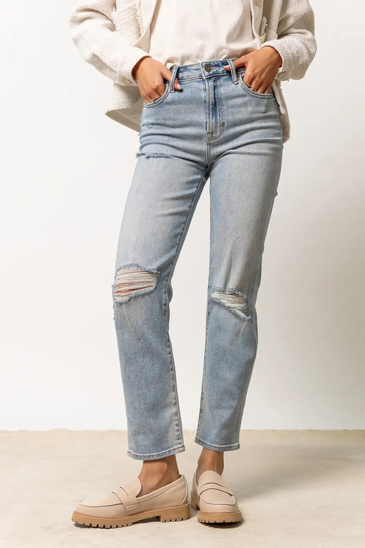 light wash denim with distressing on knees and small distressing by pockets