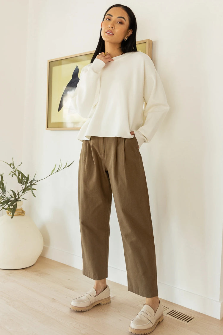 cotton trousers in khaki paired with cream sweater
