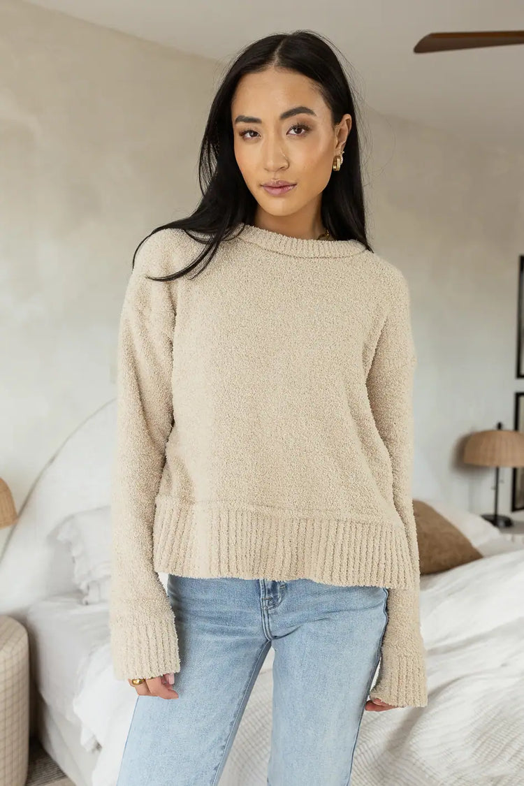 tan knitted sweater paired with light wash denim