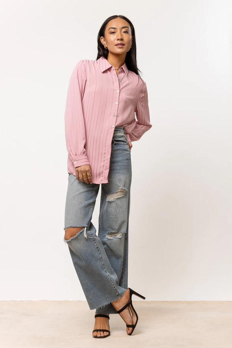 pink button up paired with distressed denim