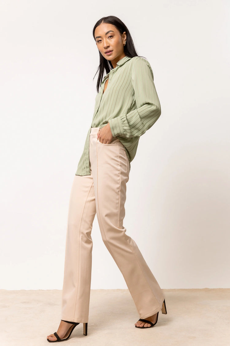 long sleeve sage button down paired with cream pants