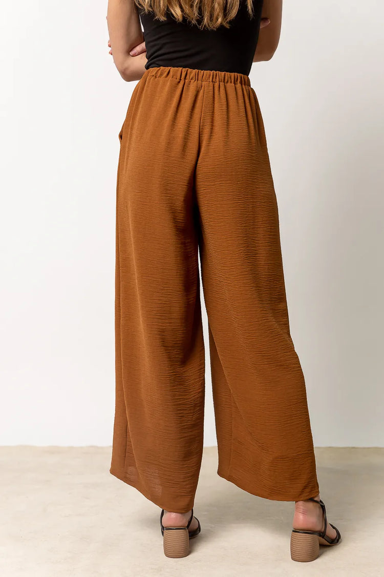brown wide leg pants paired with black heeled sandals