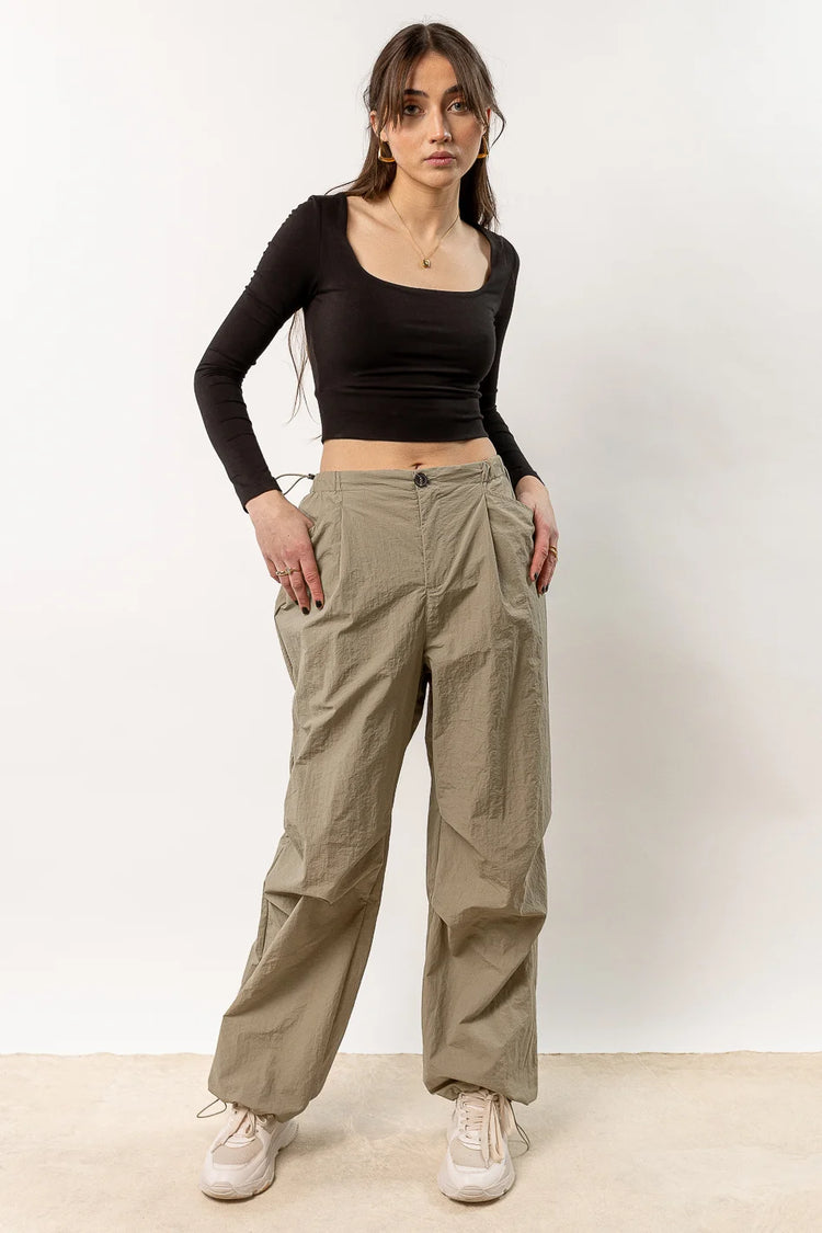 olive parachute pants paired with long sleeve crop top