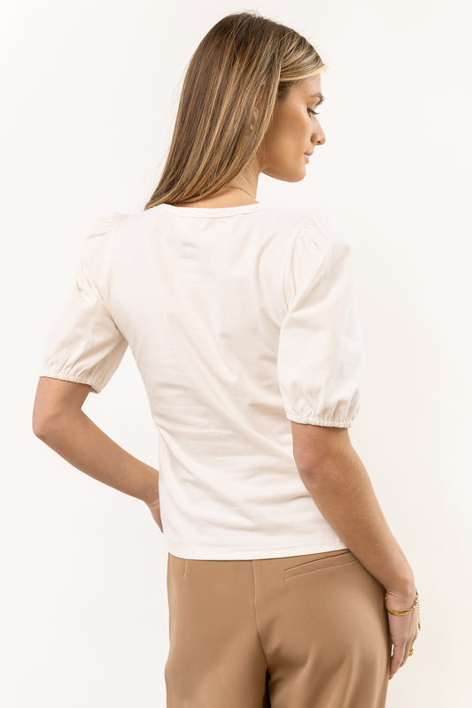 cream short sleeve shirt paired with tan trousers