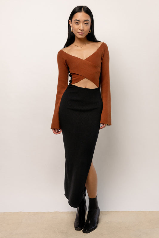 model wearing black bodycon dress with brown crisscross detail and brown long sleeves