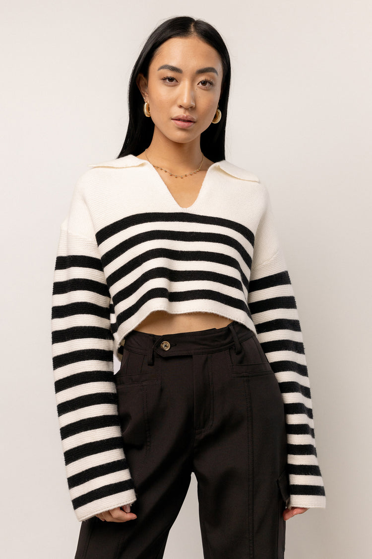 model wearing ivory and black striped sweater