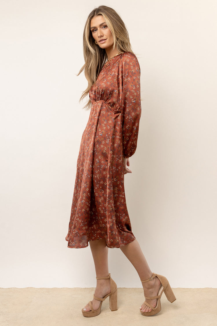 model wearing rust floral long sleeve midi dress
